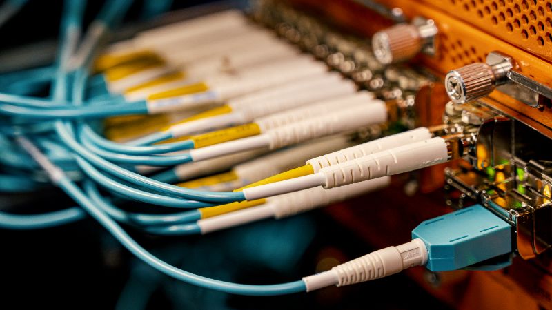Fiber optic cables plugged into network equipment ports.